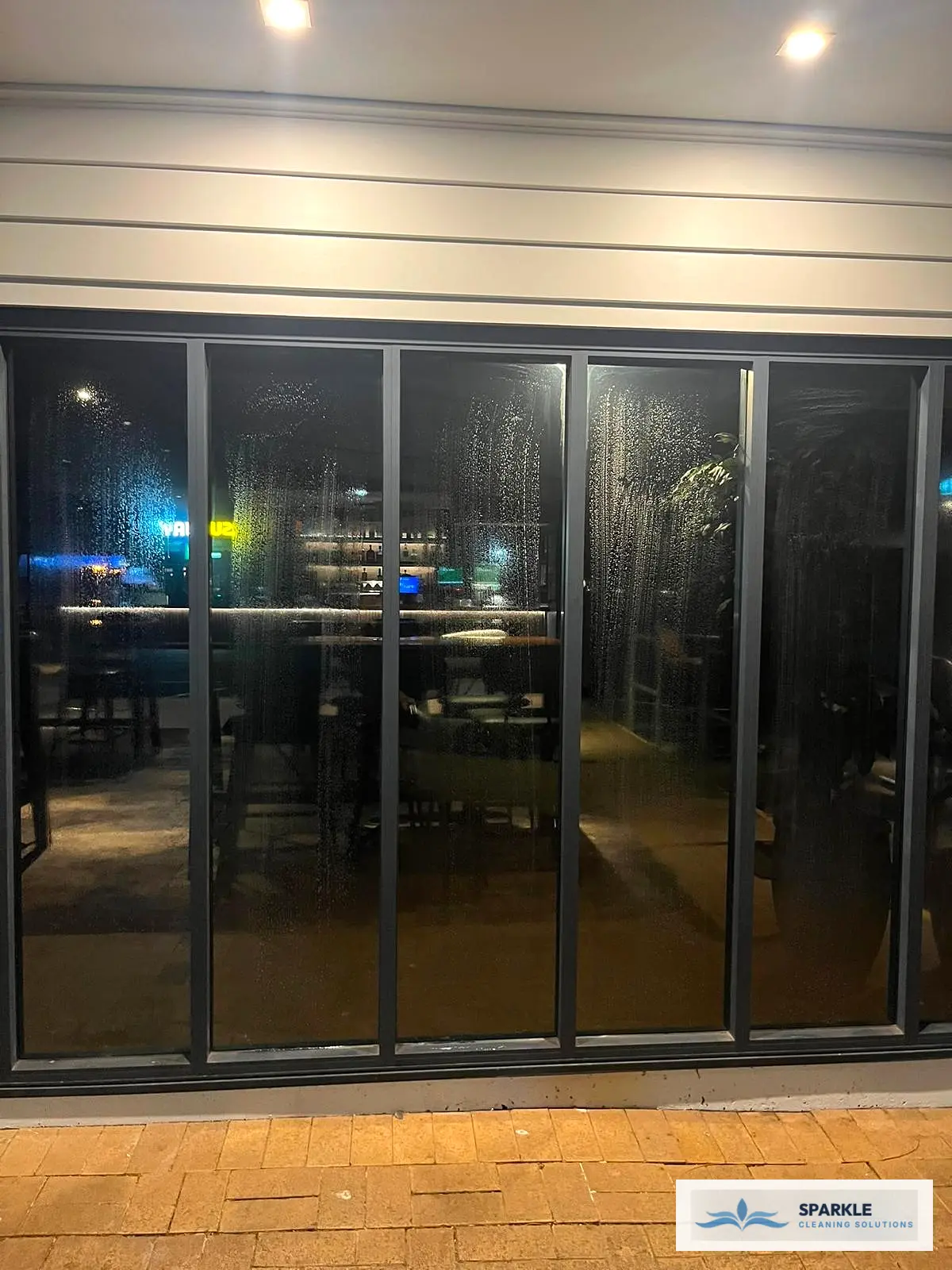 Evening glass door cleaning and facade maintenance